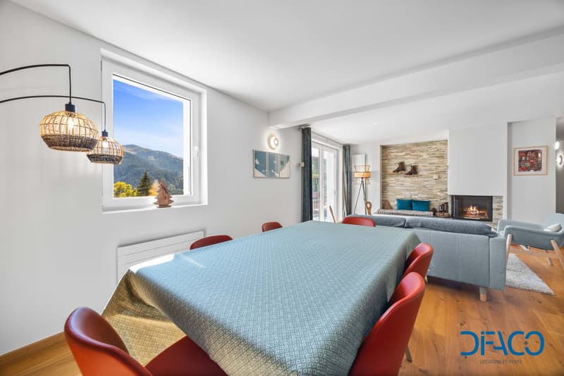Dining area with large window, fireplace, dining table, chairs, large window with view of the mountains, couch