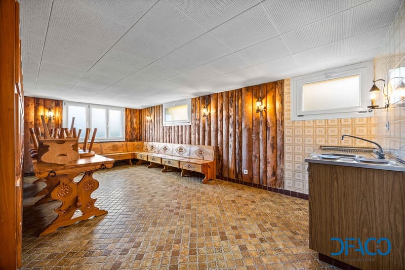 wooden walls, brick floor, wooden benches, wooden table, two sinks, wall lamps, windows