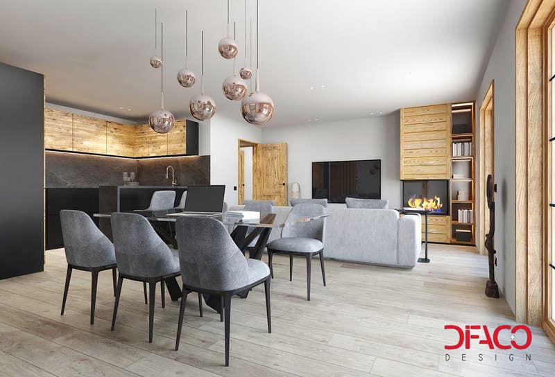 Dining area with a glass table, metal chairs, a laptop, kitchen with wooden cabinets, an island with a faucet, open living room with a fireplace, and a grey couch