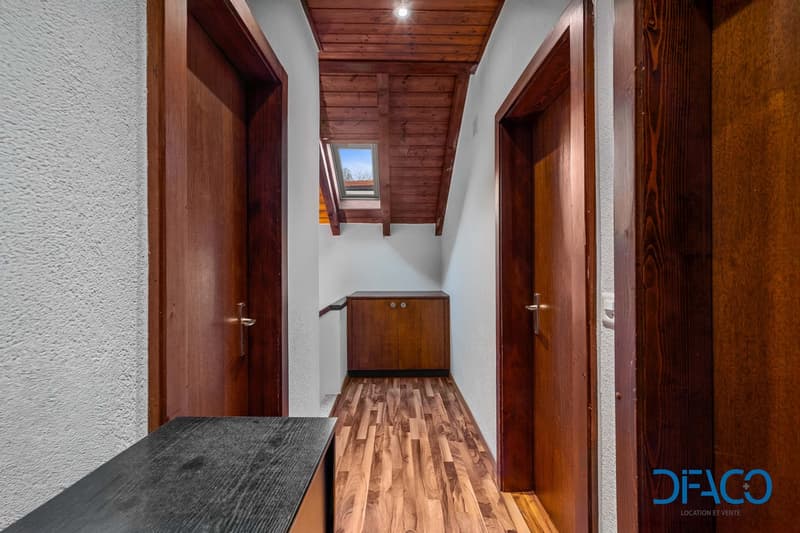 Hardwood floor, wooden doors, white walls, wooden cabinet, attic window