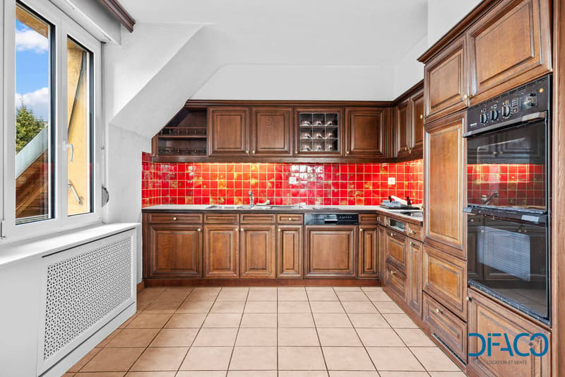 kitchen with wooden cabinets, red tiles, sink, dishwasher, oven, window