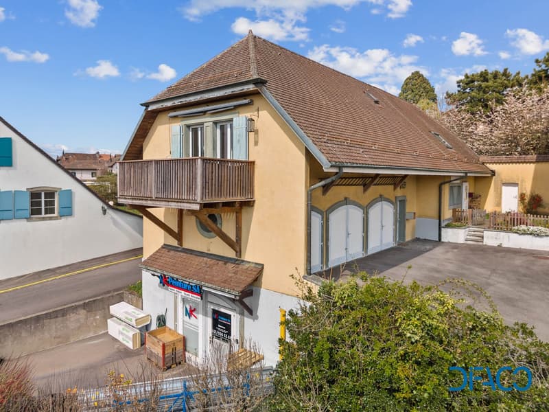 2 story house, brown roof, yellow walls, balcony, garage, parking lot