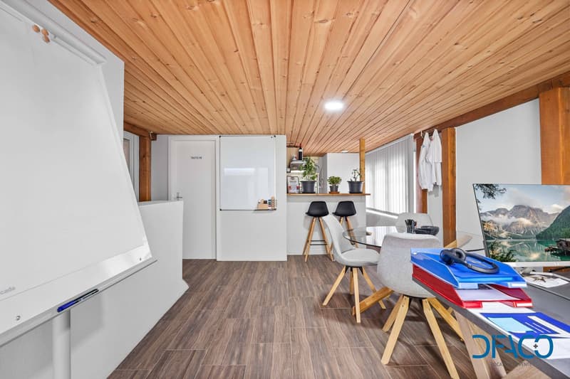 modern office room with wooden floor, white walls, wooden ceiling, whiteboard, desk, chairs, monitor, plants, and a bar counter