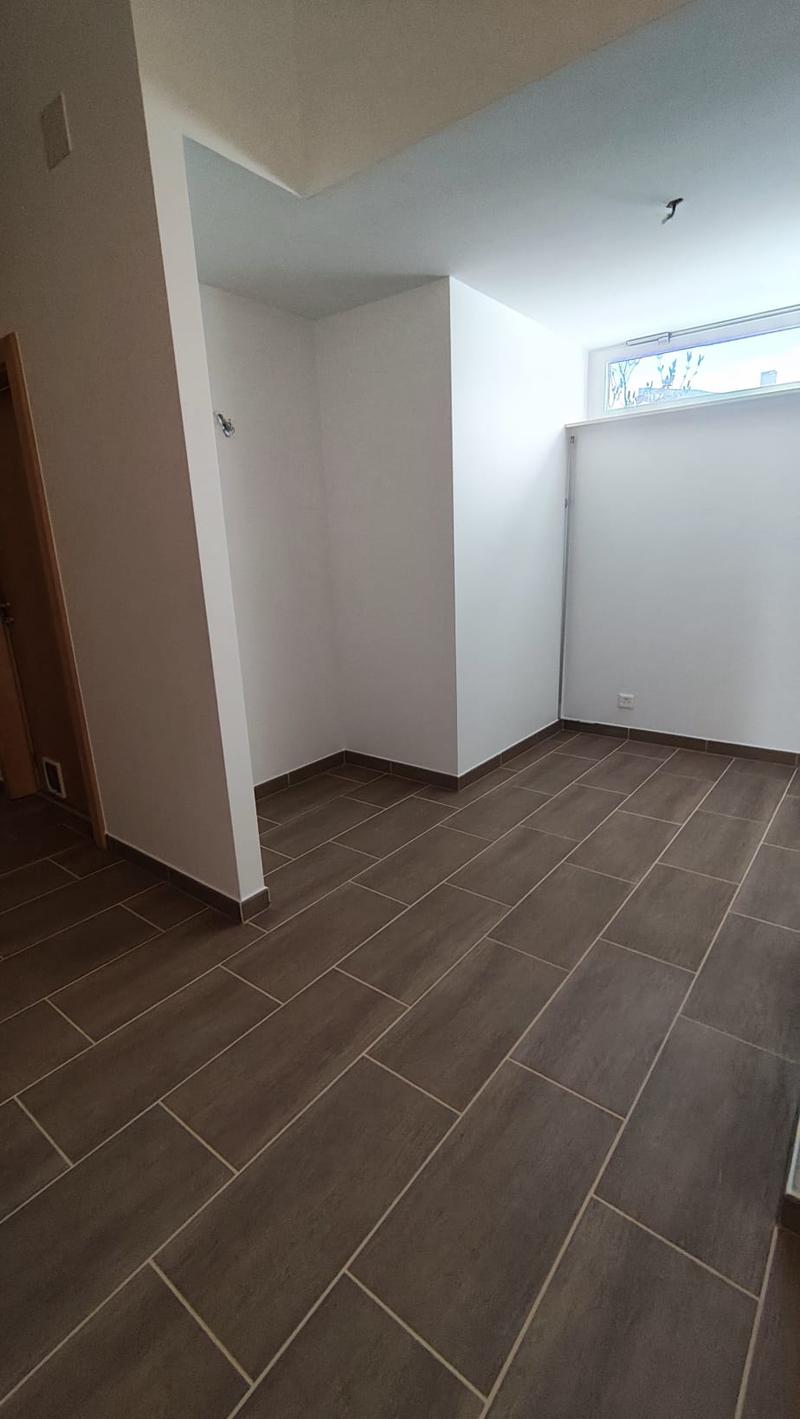 empty room, white walls, brown tiles, small window