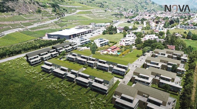 Aerial view of a community complex with several buildings, including a large swimming pool and raised ground floor