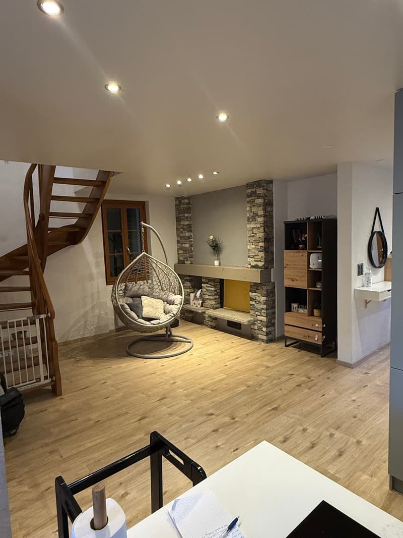 wide open space, wood flooring, spiral staircase, fireplace, suspended chair