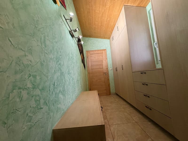 wooden ceiling, green textured wall, wooden door, wooden bench, wooden wardrobes with drawers