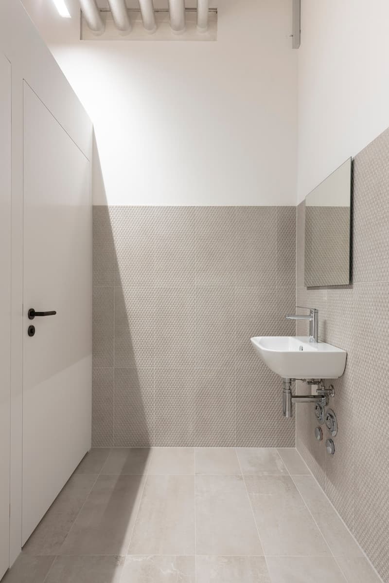 small bathroom with white tiled walls, white floor, modern sink with faucet, mirror
