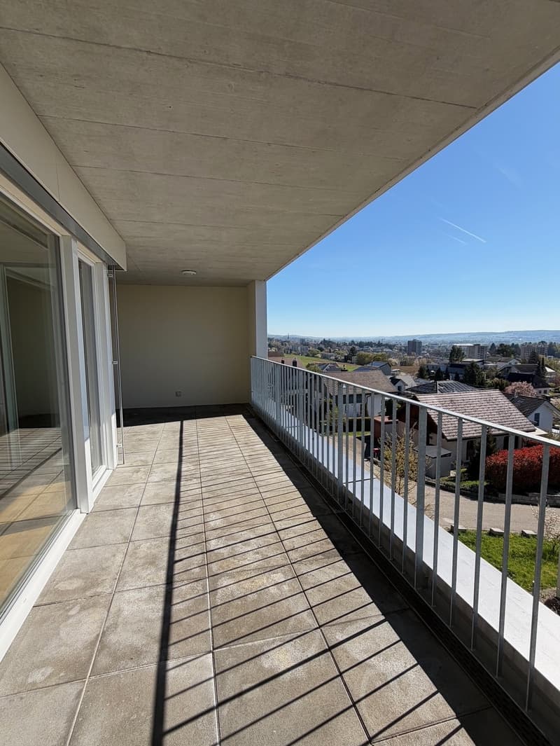 large balcony, metal railing, tiled floor, glass doors, view of the city