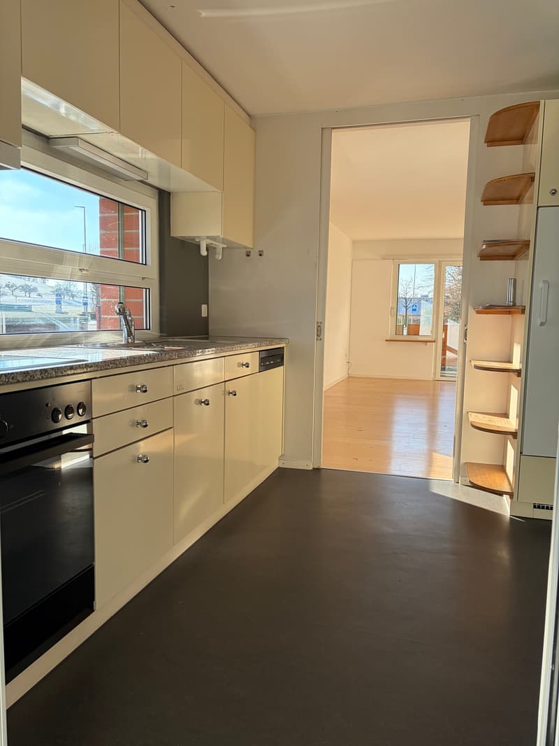 modern kitchen with white cabinets, granite countertop, black oven, dishwasher, sink with faucet, large window