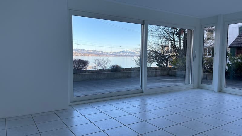 large sliding glass doors, white tiles, view of lake and mountains, terrace