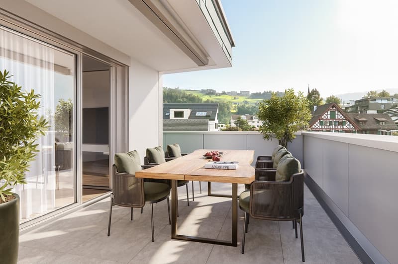Balcony with table and chairs, plants, sliding glass door, view of the town