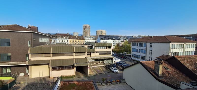 Multi-storey residential buildings, modern architecture, parking area, multiple cars parked