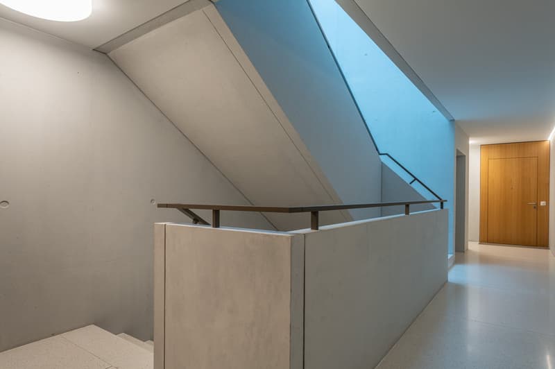 Concrete walls, staircase, corridor with large skylight