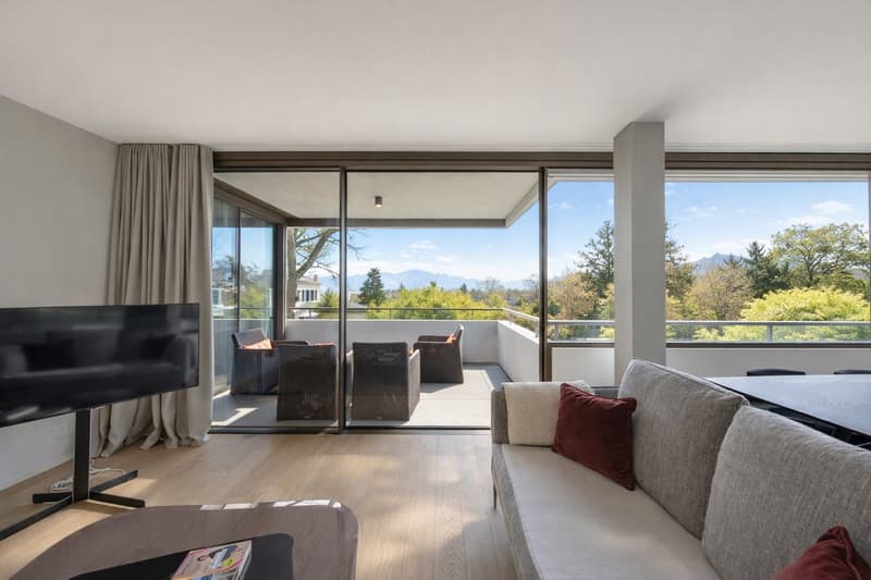 large windows, balcony with lounge chairs, sliding glass doors, open space