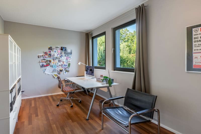 Office: large desk, computer, lamp, two chairs, bookshelf, windows