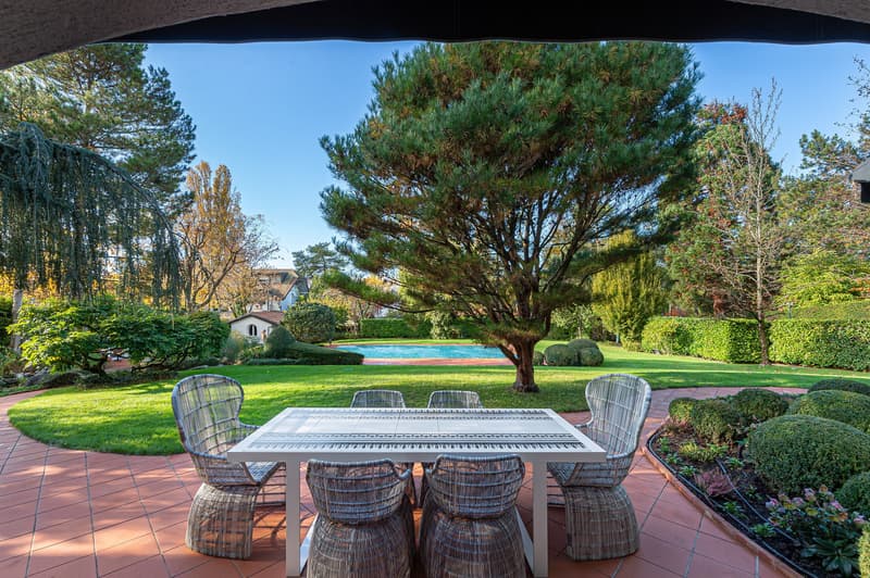 outdoor dining table with chairs, swimming pool, lawn, garden, house, trees