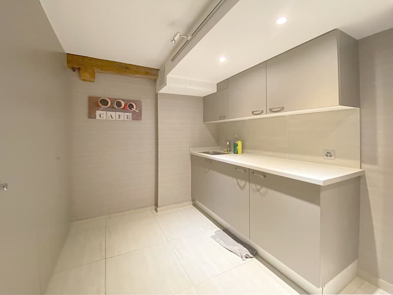 white tiled floor, white kitchen cabinets, sink, countertop with power outlet, towel, soap
