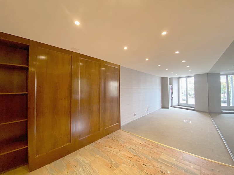 Large wooden built-in closet, exposed ceiling with recessed lighting, empty floor