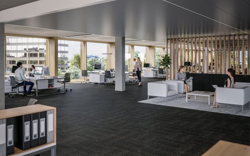 Large open-plan office space with workstations, meeting areas, and lounge seating. The space features floor-to-ceiling windows providing natural light and views of the surrounding area. The decor is modern with a mix of wood and neutral tones. There are s