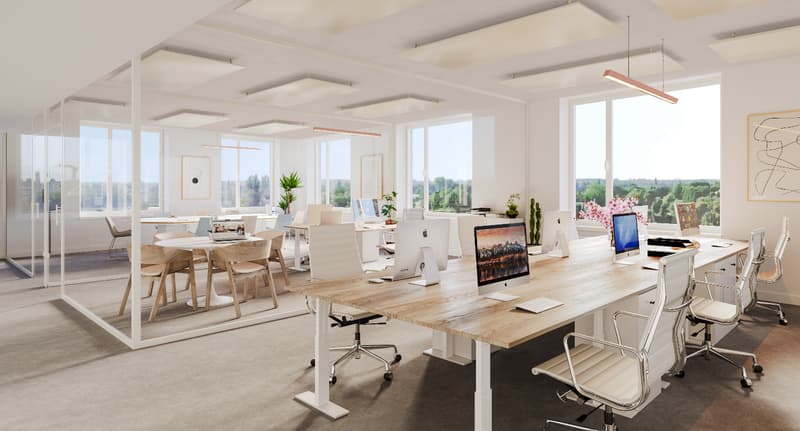 Spacious open-plan office with large windows offering a scenic view, wooden desks and chairs, computers and other office equipment, plants, and artwork on the walls.