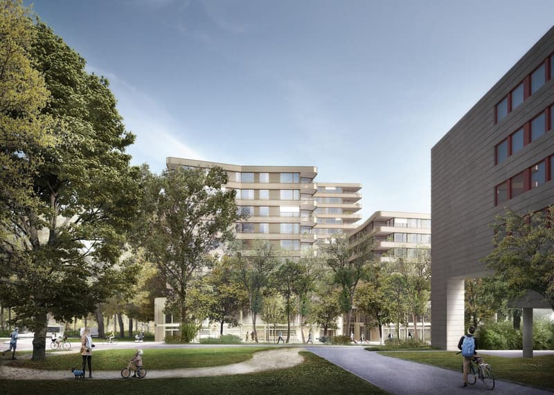 Multi-story apartment building with balconies, surrounded by trees and greenery, with people walking and cycling in the park-like setting in front of the building.