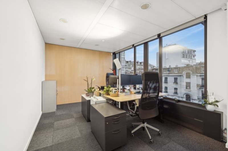 empty office room, desk, computer monitors, chairs, wooden door, window, view of building