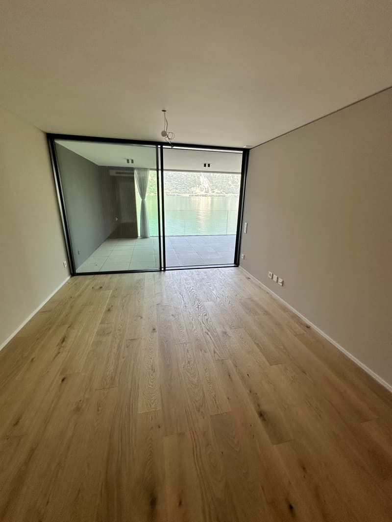 empty room, wooden floor, sliding glass doors, balcony, lake view