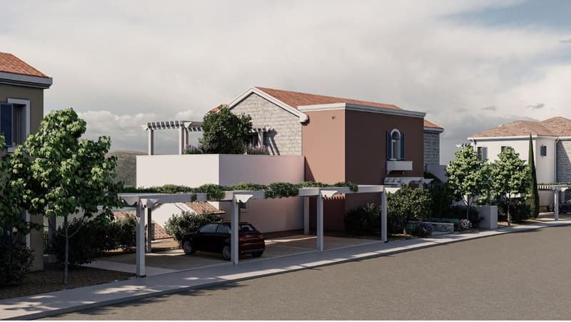 Two-story house with red tile roof, stone and stucco exterior, covered parking area, landscaped yard with trees and shrubs