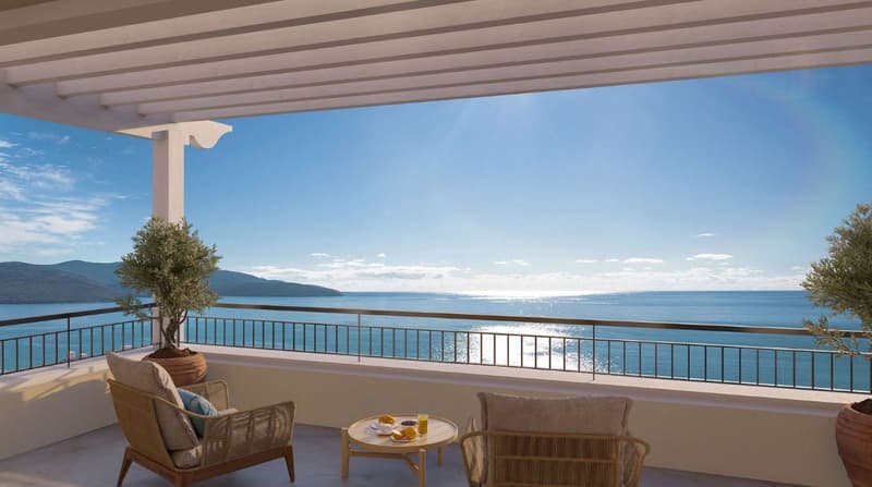 Spacious balcony with panoramic view of the sea, mountains, and blue sky. Furnished with comfortable wicker chairs and a small table, providing an ideal spot to relax and enjoy the scenic surroundings.