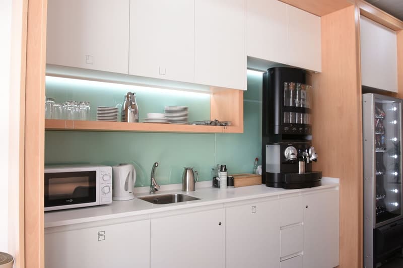 Modern kitchen with white cabinets, open shelving, stainless steel sink, microwave, coffee maker, and other kitchen appliances