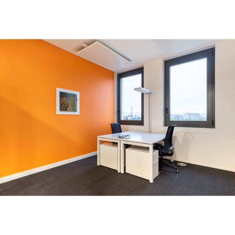 Minimalist office with orange wall, desk, chairs, floor lamp, and large windows