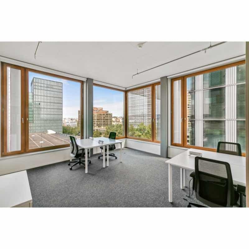modern office room with large windows, white tables and chairs, gray carpet, glass partitions, cityscape view