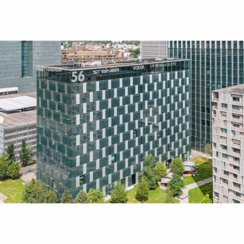 Modern office building, green glass windows, multiple floors, signage for VISEGRUPPE