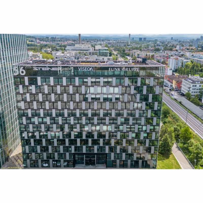 Multi-story office building with a modern architectural design, extensive glazing, and reflective windows.