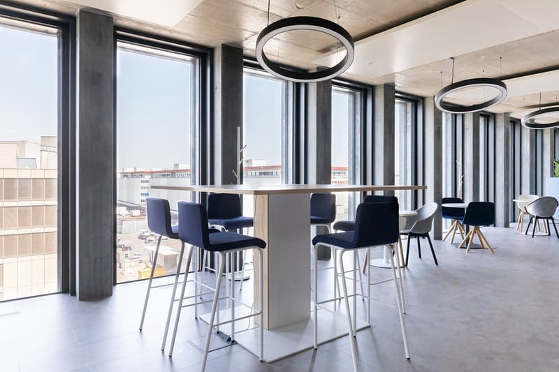 Large meeting room with modern furnishings, large windows, hanging circular lights