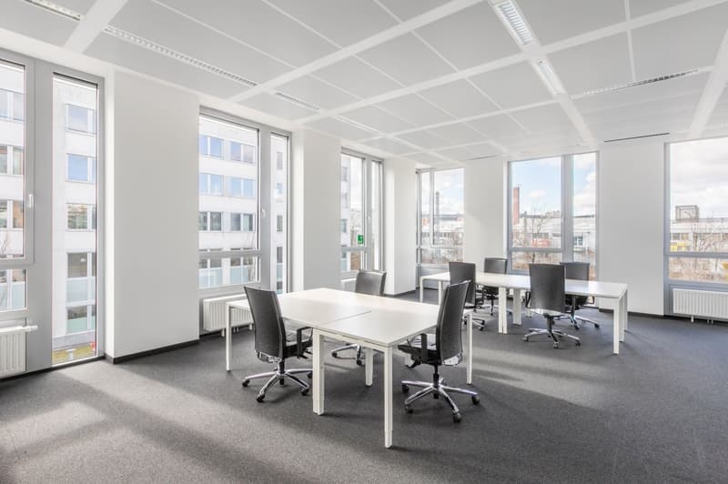 modern office room, white walls, white ceiling, white desks, black chairs, large windows, radiators