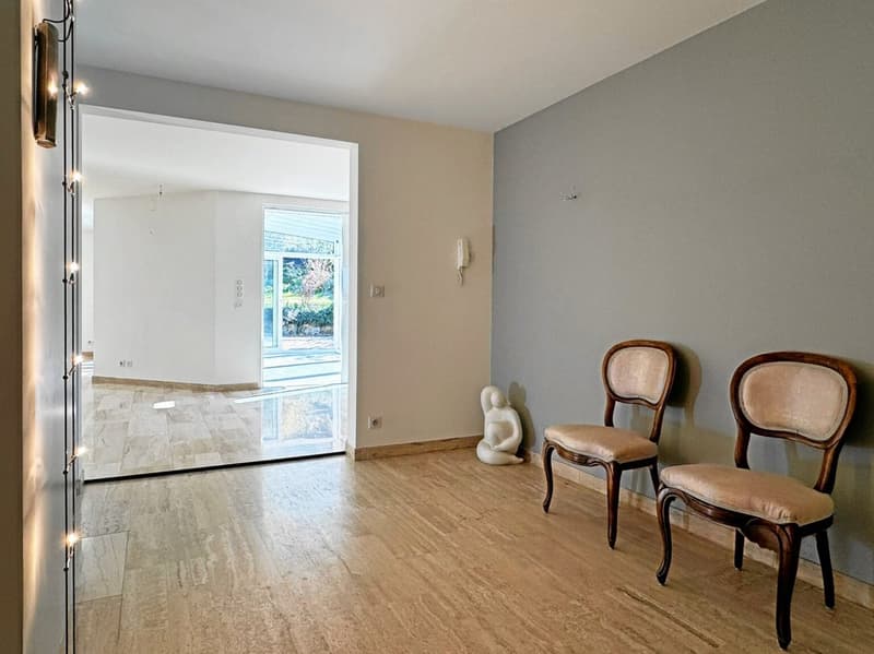 Empty room with hardwood flooring, walls, glass doors, glass walls, and view of outside