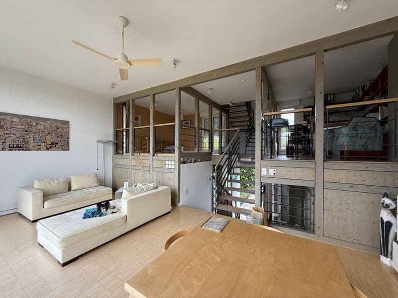 open floor plan with living room area, staircase, exposed wooden beams, ceiling fan