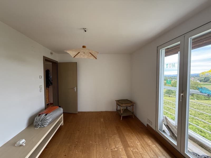 wooden floor, hanging lamp, door, storage bench, sliding glass doors, open view to the outside