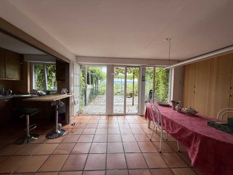 kitchen with counter and sink, dining area with large window, open to balcony, wooden flooring