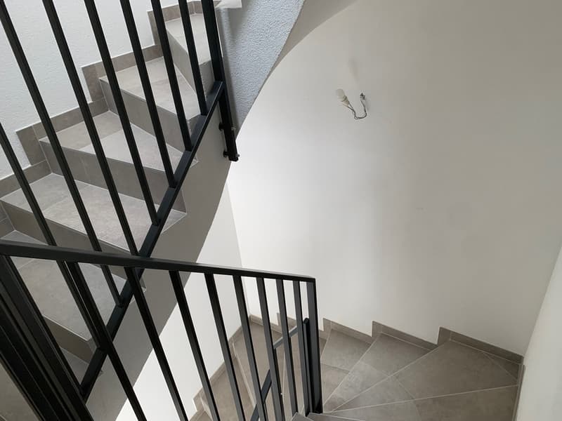 A staircase with black railings and grey steps
