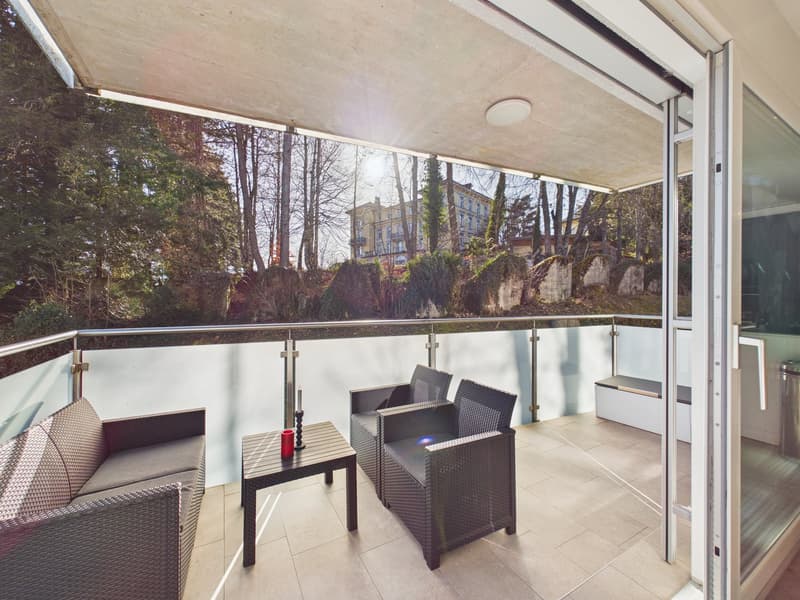 balcony, chairs, coffee table, balcony railing, glass door, sunlight, trees