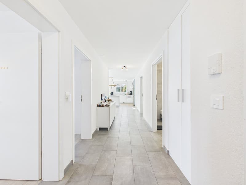 long hallway, tile floor, closed doors on both sides