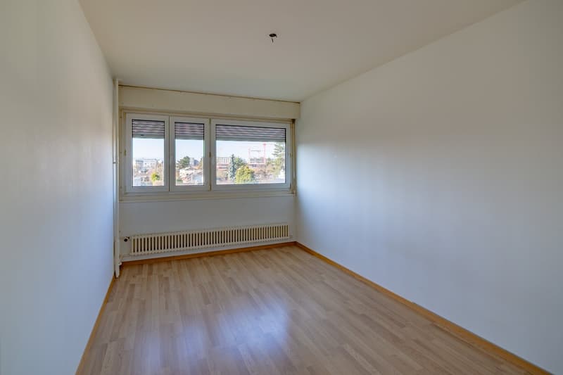 empty room, wooden floor, white walls, large window, radiator