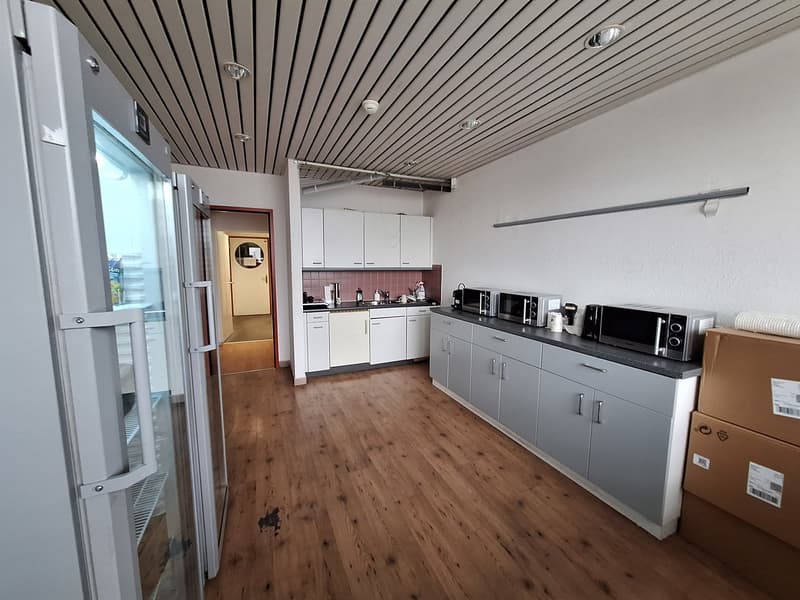 kitchen with wooden floor, white cabinets, microwave, refrigerator, sink, boxes