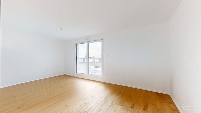 Empty room with wooden floor, white walls, and a large glass window with an outside view