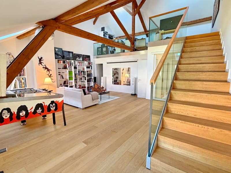 wooden flooring, exposed wooden beams, white couches, wooden stairs, arched glass handrail, shelves with books, arched mirrors, arched doorway, arched windows