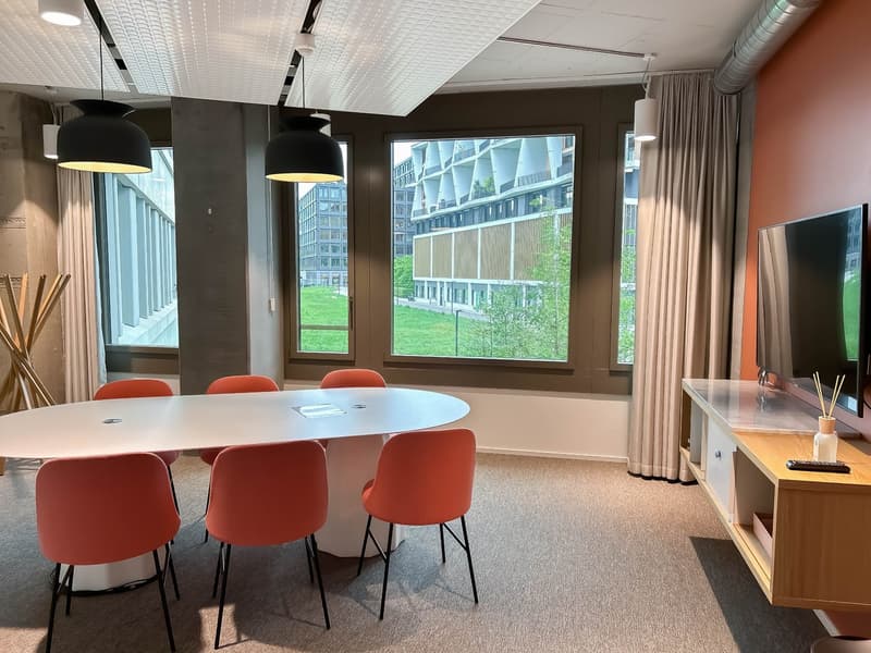 conference room with large windows, round table, red chairs, TV, wooden cabinet, remote control