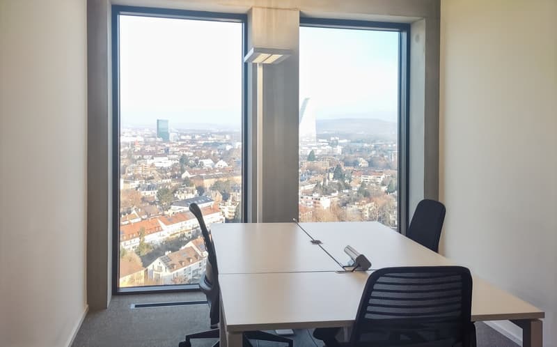 Large office space with panoramic city view through floor-to-ceiling windows, white desk, black office chair